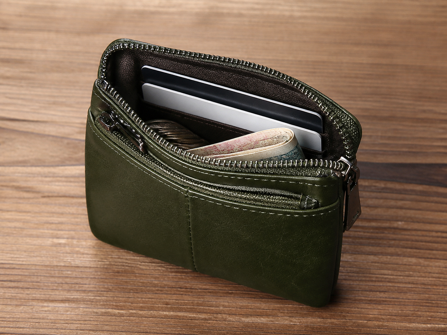 Open green leather wallet holding cards, folded cash, and coins